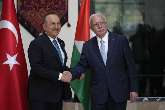 Turkish FM Mevlut Cavusoglu (L) shakes hands with Palestinian FM Riad Al-Malki, in the West Bank town of Ramallah, Tuesday, May 24, 2022. (AP)