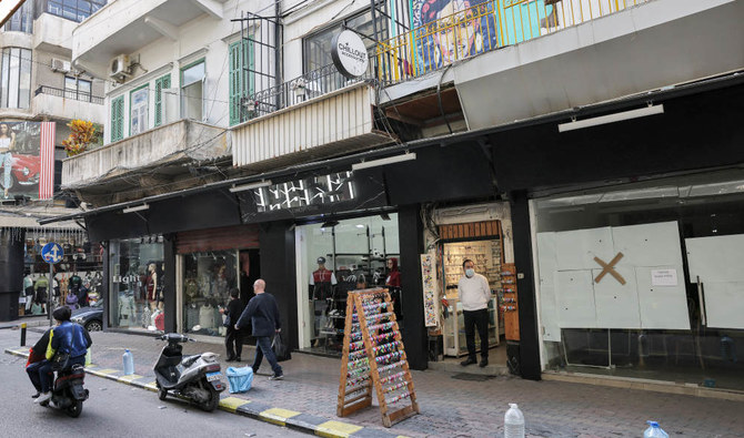 People walk past closed or half-open shops in the popular market of the Burj Hammoud neighbourhood of Lebanon's capital Beirut on December 14, 2021. (AFP)