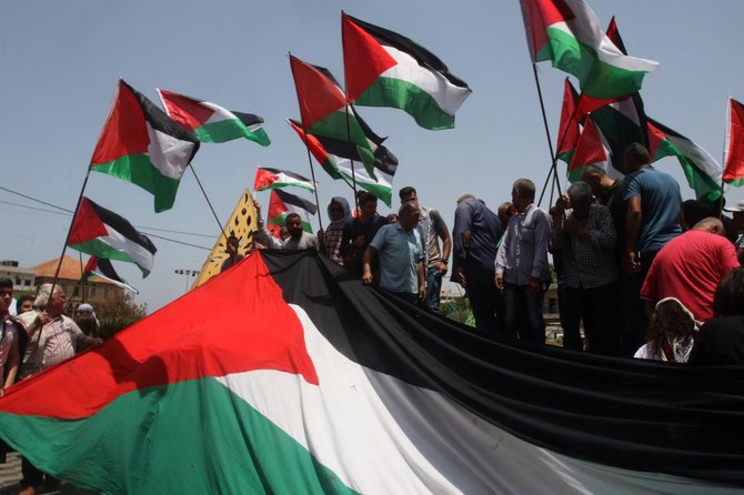 Protesters lift Palestine’s flag during a rally in support of Jerusalem’s Al-Aqsa mosque in Lebanon’s southern city of Sidon on May 29, 2022. (AFP)