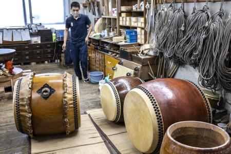 This photo taken on April 26, 2022 shows a craftsperson working on the renovation of a Japanese taiko drum at the Miyamoto Unosuke workshop in Tokyo. (AFP)