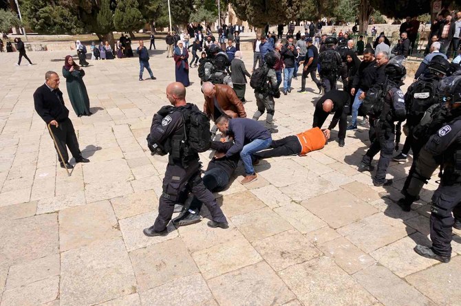 Two people lie on the ground during clashes between Israeli security forces and Palestinians on May 5, 2022. (AFP)