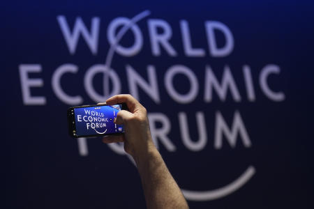 A man takes a video of the logo of the World Economic Forum at the eve of the event in Davos, Switzerland, Saturday, Jan. 21, 2022. The annual meeting of the World Economic Forum is taking place in Davos from May. 22 until May. 26, 2022. (AP)