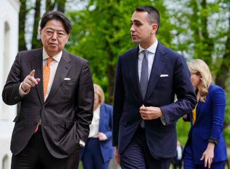 Japanese Foreign Minister Yoshimasa Hayashi (left) and Italian Foreign Minister Luigi Di Maio talk as they walk through the garden with other participants during the G7 Foreign Ministers meeting in Wangels, northern Germany, on May 13, 2022. (AFP)