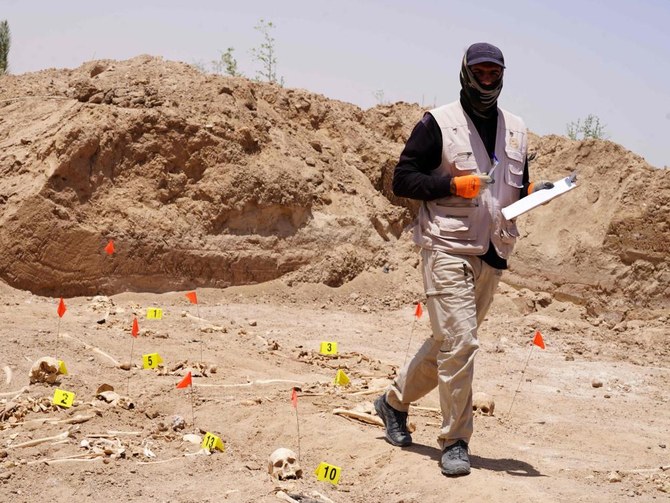 A forensic expert working for the Iraqi authorities, works at a mass grave where human remains were exhumed, near the southern city of Najaf, on Saturday. (AFP)