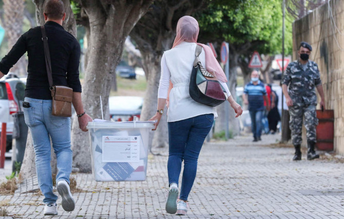 Lebanese civil servants assigned to run polling stations receive sealed ballot boxes at the governmental saray in Sidon on May 14, 2022 on the eve of the parliamentary elections. (AFP)
