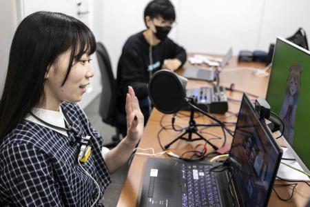 This photo taken on April 7, 2022 shows Mayu Iizuka, a virtual YouTuber who voices and animates a character called Yume Kotobuki, hosting a livestream at a studio in Tokyo. (AFP)