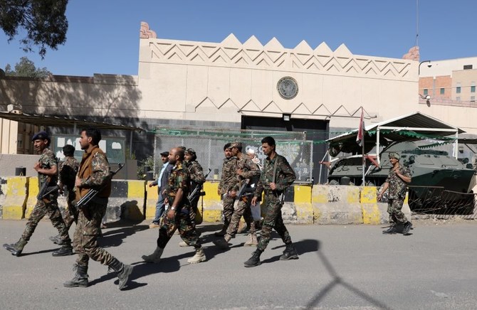 Houthi militants walk past the US embassy in Sanaa, Yemen. (Reuters)