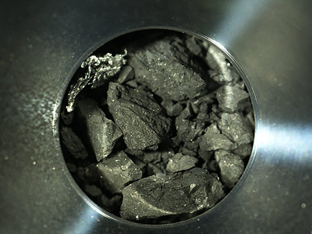 This handout photograph released by the Japan Aerospace Exploration Agency (JAXA) on December 24, 2020 shows samples of soil from the asteroid Ryugu, inside C compartment of the capsule collected by the Hayabusa-2 space probe, at JAXA Sagamihara Campus in Sagamihara, Kanagawa prefecture. (AFP)