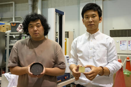 Tokyo University researchers Yuya Sakai (right) and Kota Machida pose for photos with products they made out of 'food cement' at their laboratory in Tokyo on May 26, 2022. (AP)