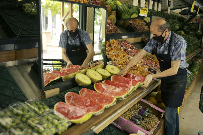 A worker arranges fruit for sale a food market in Ankara, Turkey, Friday, June 3, 2022. (AP)