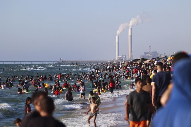 Palestinians swim in the Mediterranean sea off a beach in Beit Lahia in the northern Gaza Strip on June 10, 2022. (AFP)