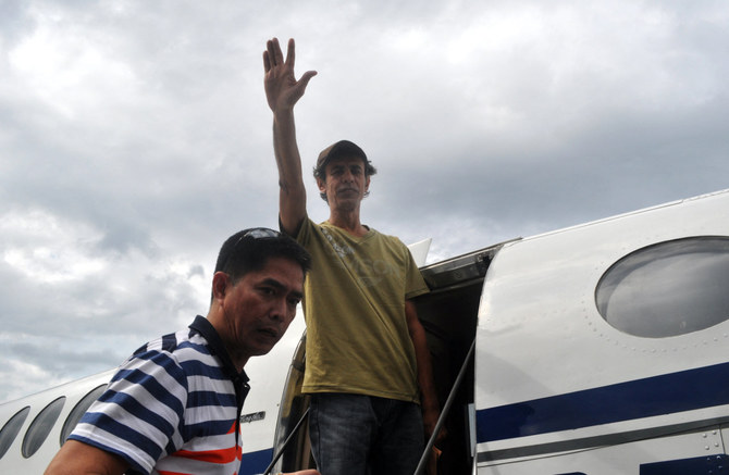 Journalist Baker Atyani waves as he boards a plane at Jolo airport in the southern Philippines on Dec. 6, 2013, a day after his escape from Abu Sayyaf bandits. (AFP File photo)