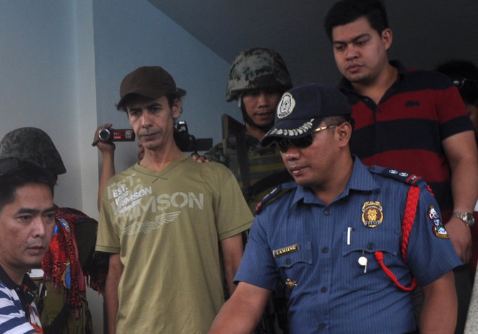 Baker Atyani is escorted by the police to the Jolo airport after his escape from Abu Sayyaf bandits. (Supplied)