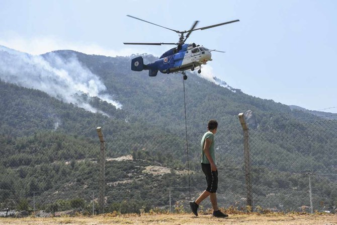A firefighting helicopter takes water from a lake in Akcaova Village in Aydin in August 2021 Turkey where a fire broke out on Tuesday near the Aegean coastal resort of Marmaris. (AP/File)