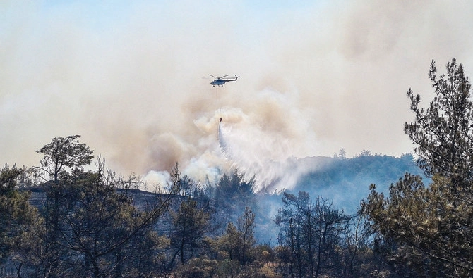 A firefighting helicopter drops water on a wildfire near Marmaris, a town in Turkey’s Mugla province. (Reuters)