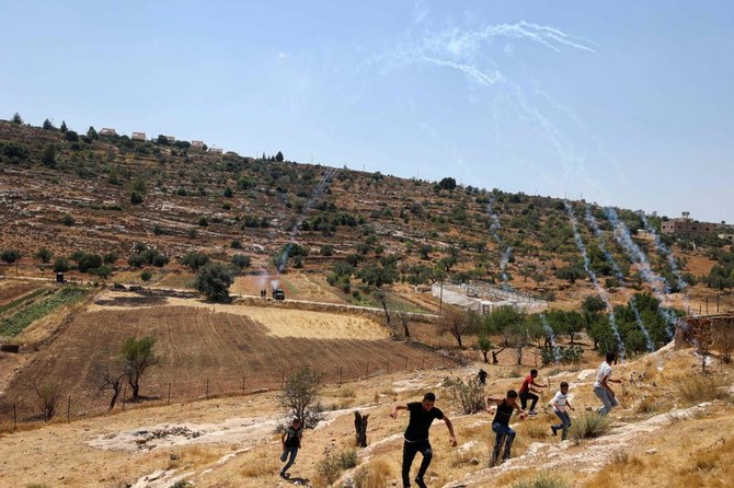 Palestinian demonstrators move away from Israeli tear gas while protesting attempts by Israeli settlers from the settlement of Eli in the occupied West Bank. (AFP)