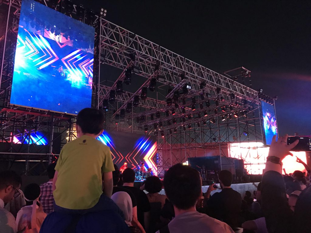 Fans cheering and waving their hands during one of Flow flaming songs.