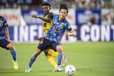 Japan's Takefusa Kubo fights for the ball with Ghana's Mohammed Kudus during the Kirin Cup football match between Japan and Ghana at Noevir Stadium in Kobe on June 10, 2022. (AFP)