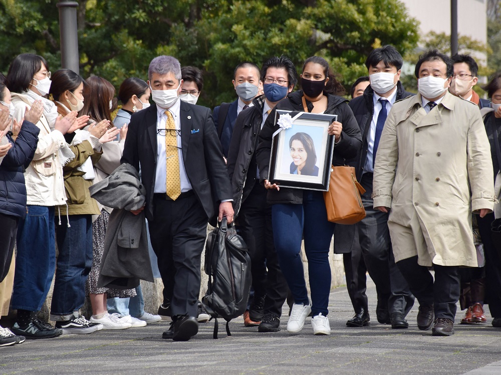 Sister of a Sri Lankan woman Wishma Sandamali, who died a year ago while in Japanese immigration detention, carries a picture of her late sister as she walks to the Nagoya district court on March 4, 2022, to file a lawsuit against the government of Japan. (AFP/file photo)