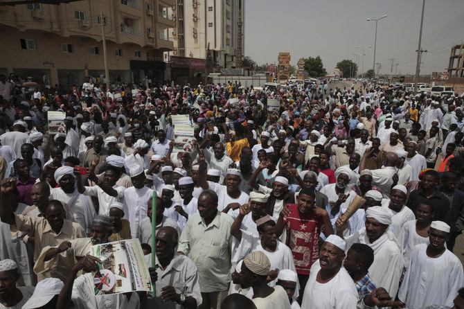 Dozens of people gather in front of the office of the UN Integrated Transition Assistance Mission in Sudan in support of Sudan’s military leaders, in Khartoum on Wednesday. (AP)