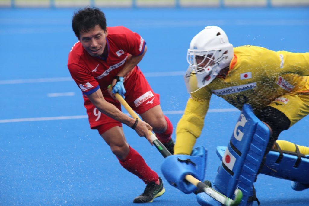 Hockey players from Japan’s national team (Red) and a select team (green) play at the reopening of the Olympic Hockey Stadium in Tokyo. (ANJ/ Pierre Boutier)