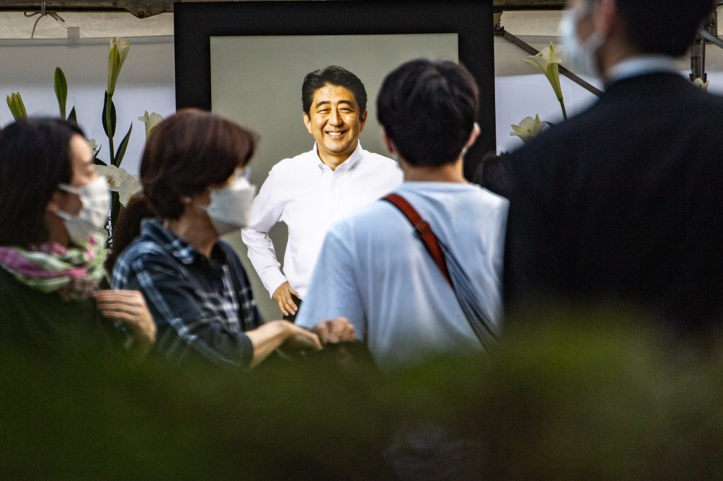 People offer flowers to late former Japanese prime minister Shinzo Abe at Zojoji Temple in Tokyo on July 11, 2022. (AFP)