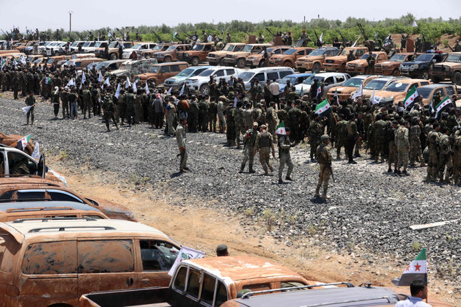 Turkish-backed Syrian rebel fighters parade in Aleppo province on July 2, 2022. Turkey has postponed its planned new offensive against Kurdish forces because of Russia's objections. (AFP)