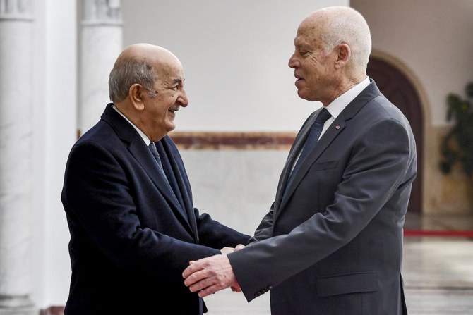 A file photo taken in December 2021, Tunisia’s President Kais Saied shakes hands with Algeria’s President Abdelmajid Tebboune at Tunis-Carthage International Airport. (AFP)