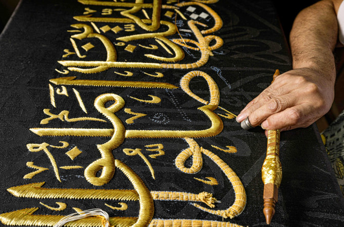 An embroiderer sews with gold thread a verse from the Holy Koran, Islam's holy book, onto a replica of the Kiswa, the cloth used to cover the Kaaba at the Grand Mosque in the Muslim holy city of Makkah. (AFP)