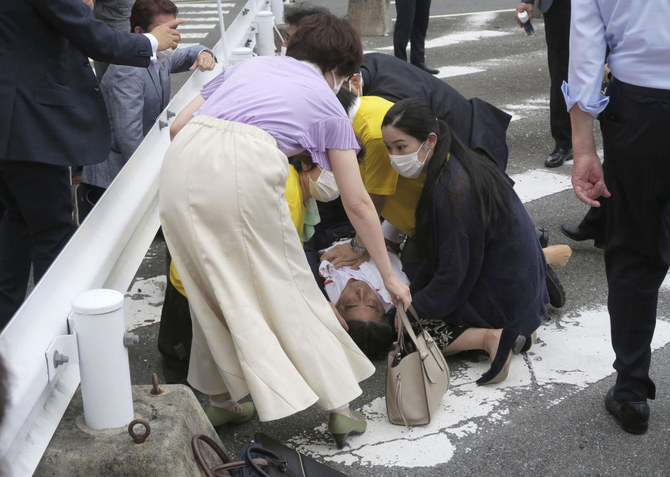 Japan’s former Prime Minister Shinzo Abe, center, falls on the ground in Nara, western on July 8, 2022 after apparently being shot. (Kyodo News via AP)