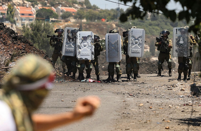 Israeli forces clash on July 22, 2022, with demonstrators protesting the expropriation of Palestinian land in Kfar Qaddum village, occupied West Bank. (AFP)