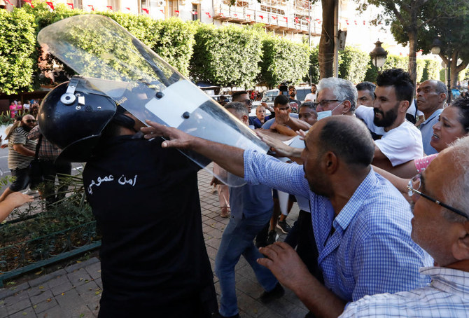 Demonstrators scuffle with police during a protest organized by Tunisian civil society groups against the upcoming President Kais Saied’s referendum on a new constitution in Tunis on Friday. (Reuters)