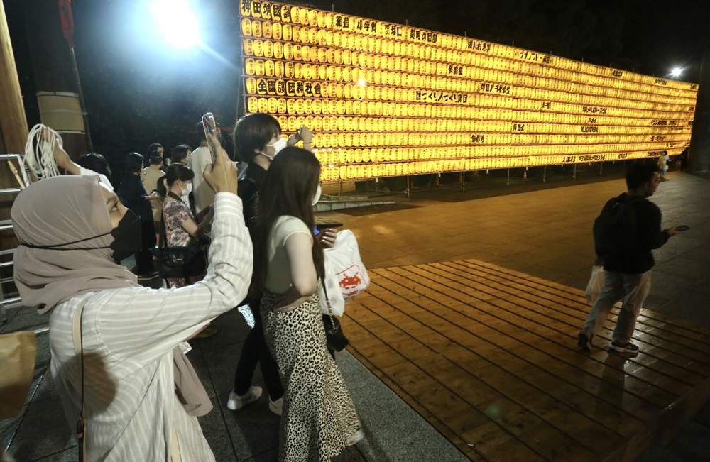 Visitors take photos at the Mitama Festival at Yasukuni Shrine in Tokyo to observe the lantern illuminations and mark the remembrance of ancestors who sacrificed their lives for the country. (ANJP/ Pierre Boutier)