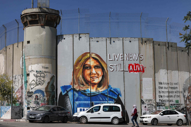 A woman walks past a mural depicting slain Al Jazeera journalist Shireen Abu Akleh, who was killed in Jenin in May. (AFP)