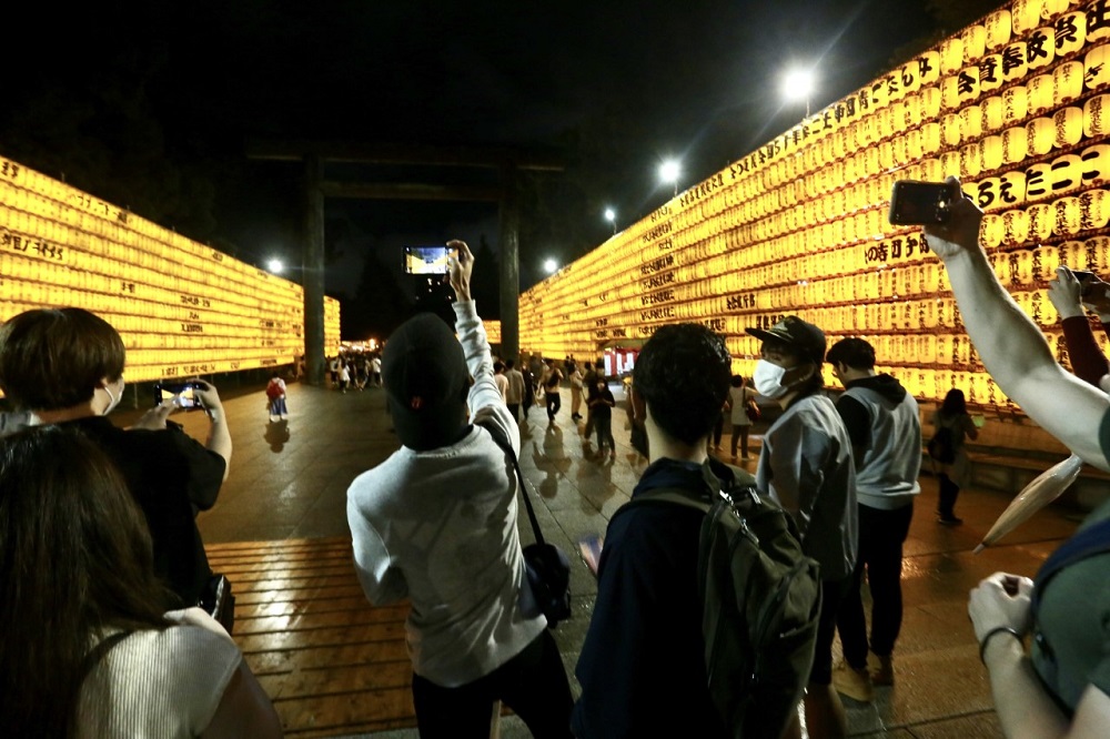 Visitors take photos at the Mitama Festival at Yasukuni Shrine in Tokyo to observe the lantern illuminations and mark the remembrance of ancestors who sacrificed their lives for the country. (ANJP/ Pierre Boutier)