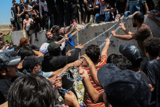 Iraqi protesters remove concrete barriers to cross the bridge toward the Green Zone area in Baghdad on July 30, 2022. (AP)