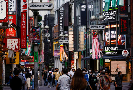 Passersby wearing protective face masks walk on the street, amid the coronavirus disease (COVID-19) pandemic, in Tokyo. (Reuters)