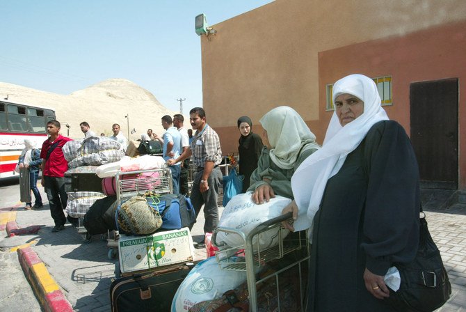 Palestinian families wait at the Israeli border control to cross the King Hussein (Allenby) bridge on July 5, 2002. (AFP)