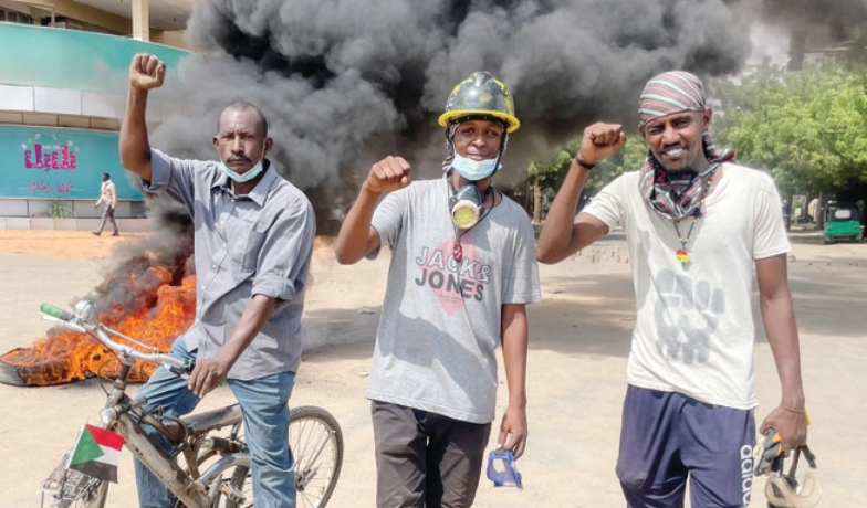 Protesters gesture in front of burning tires during a rally against the country’s military leadership in Khartoum, Sudan. (Reuters/File)