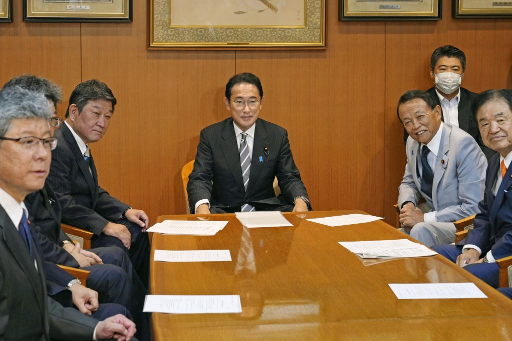 Japanese Prime Minister Fumio Kishida poses for a photo before a meeting with his party members including Toshimitsu Motegi, second left, and Taro Aso, second right, at the party's headquarters in Tokyo, Aug. 10, 2022. (File photo/Kyodo News via AP)