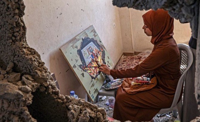 A Palestinian artist paints in the house of Diana Al-Amour, who was killed in an Israeli airstrike, Gaza, Aug. 23, 2022. (AFP)