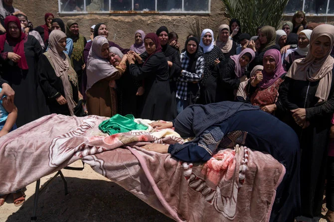 Palestinians mourn 16-year-old Amjad Abu Alia, who died shortly after he was hit by Israeli army fire in the village of Mughayer, north of Ramallah, on July 30, 2022. (AP)