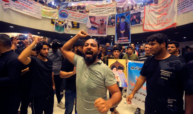 Followers of Shiite cleric Muqtada Al-Sadr hold posters with his photo during a sit-in protest, in Baghdad, Iraq, Wednesday, Aug. 3, 2022. (AP)
