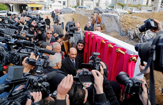 Video journalists and photographers work as Mufid Hassayneh, Palestinian minister of public works, center, speaks during a cornerstone ceremony for rebuilding Zafer 4 Tower in Gaza, in the northern Gaza Strip, on Feb. 18, 2015. (AP)
