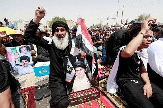 Supporters of Iraqi Shiite cleric Muqtada Sadr carry his portrait following Friday prayers outside the parliament building in the Green Zone of Baghdad on Aug. 12, 2022. (AFP)