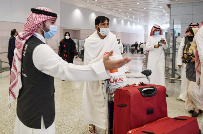A mask-clad traveller arriving to Saudi Arabia to perform the year-round Umrah pilgrimage, is welcomed at King Abdulaziz International Airport in Jeddah. (AFP)