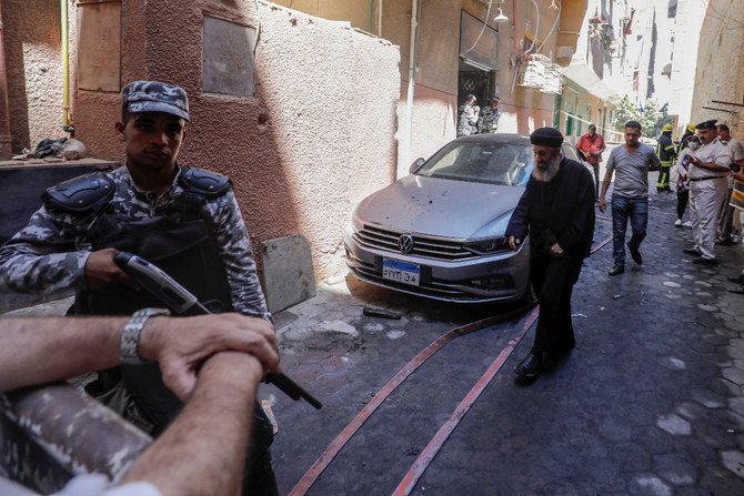 People and policemen gather near the scene where a deadly fire broke out at the Abu Sifin church in Giza, Egypt. (Reuters)