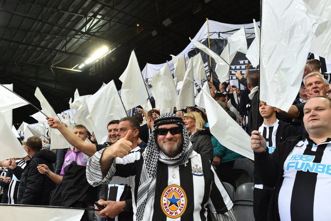 Newcastle United fans celebrate the club's recent take over by a Saudi-led consortium during an English Premier League football match on Oct. 17, 2021 in Newcastle-upon-Tyne, England. (AFP)