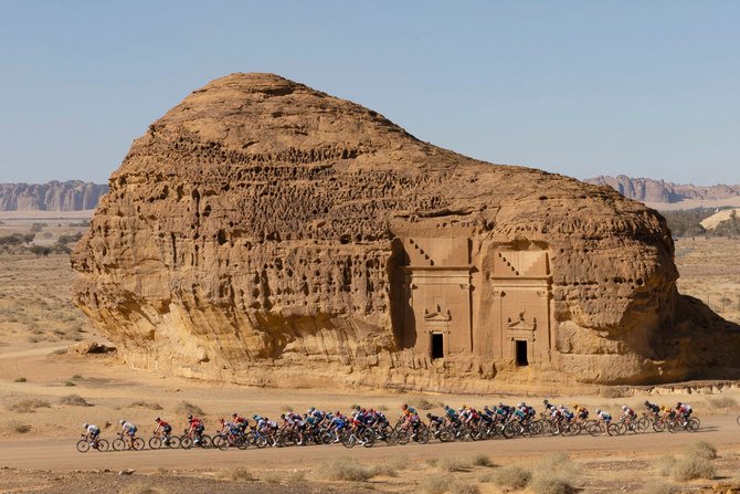 The peloton passes by ancient Nabataean carved tombs during the Saudi Tour northwestern city of AlUla on Feb. 1, 2022. (AFP)