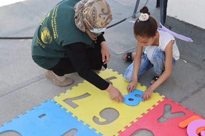 Reham Abdel Karim Matar playing with trainer. (KSrelief)